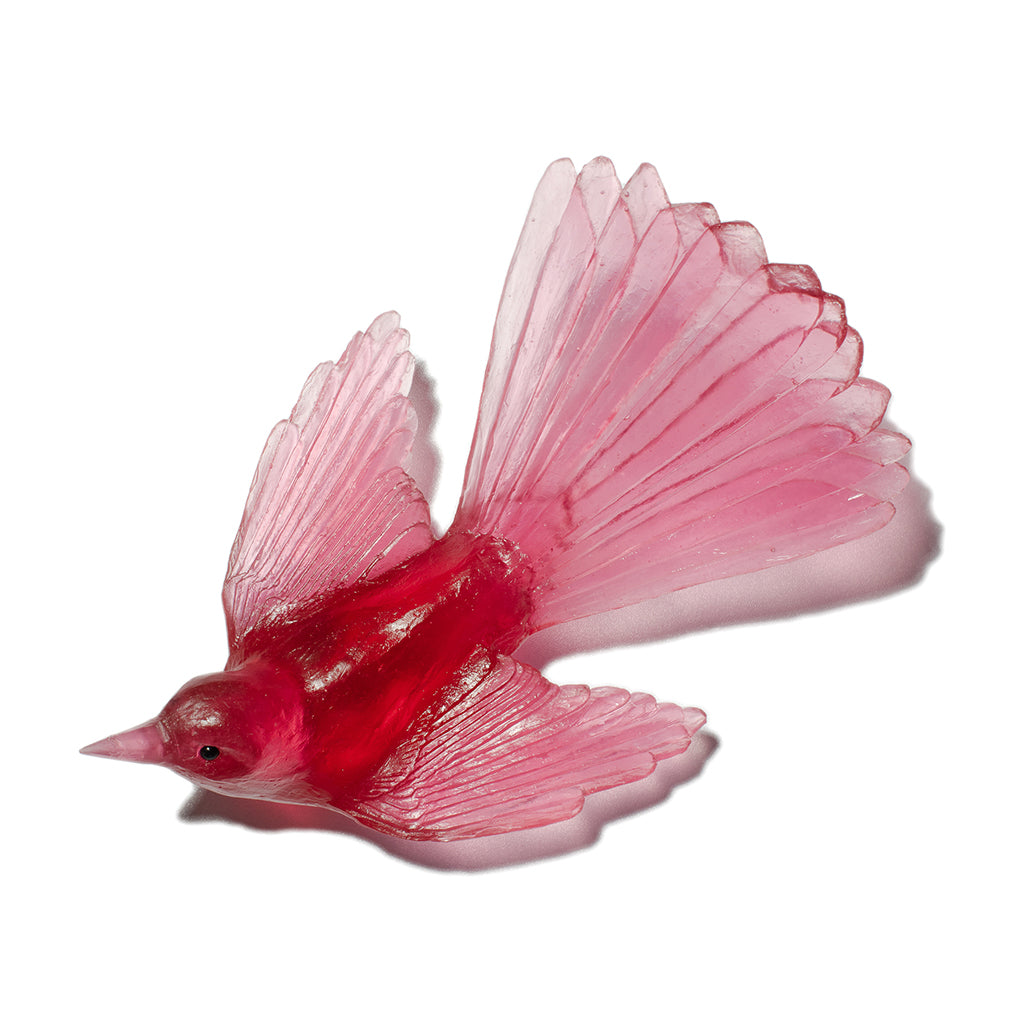 A translucent red bird-shaped decorative object with delicate fan-like tail and wings, shown on a plain white background.