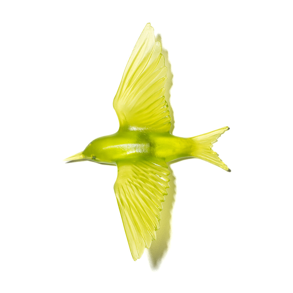 A translucent lime green bird figurine, shaped as though in flight with wings spread, isolated on a solid white background.
