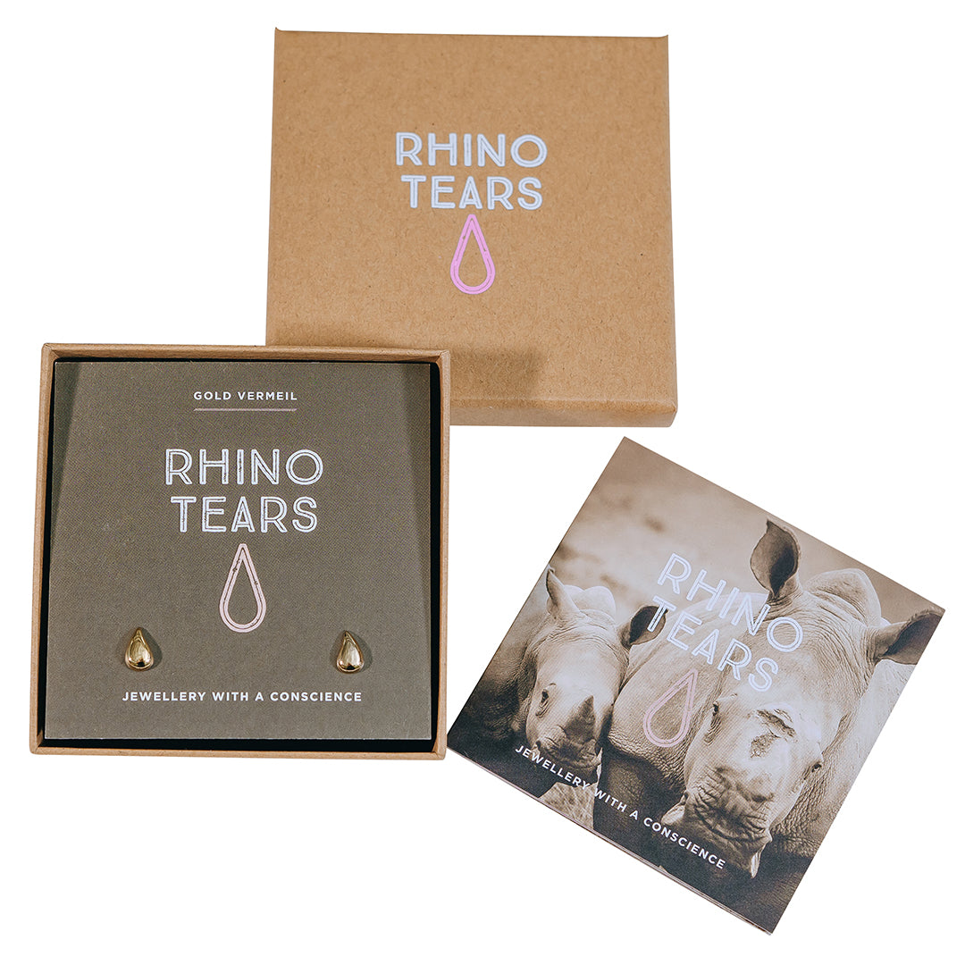 The image shows a set of Rhino Tears earrings, including a gold-plated tear drop design, packaged in a box with the brand and product name, and a conservation message.