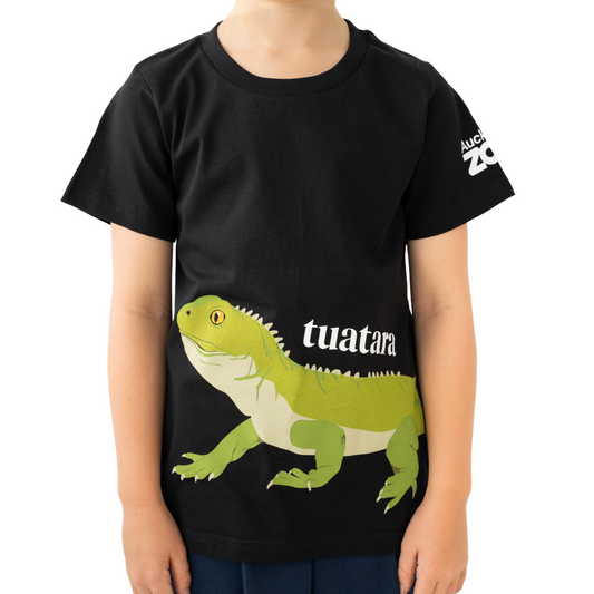 Child wearing a black t-shirt with a green tuatara design and 'tuatara' text on a white background