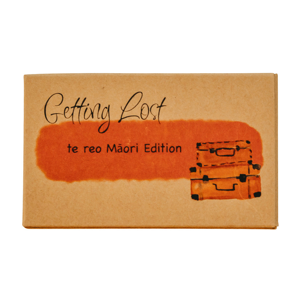 Packaging for 'Getting Lost' card game, featuring the title and 'te reo Máori Edition' text, with a suitcase illustration in orange tones.