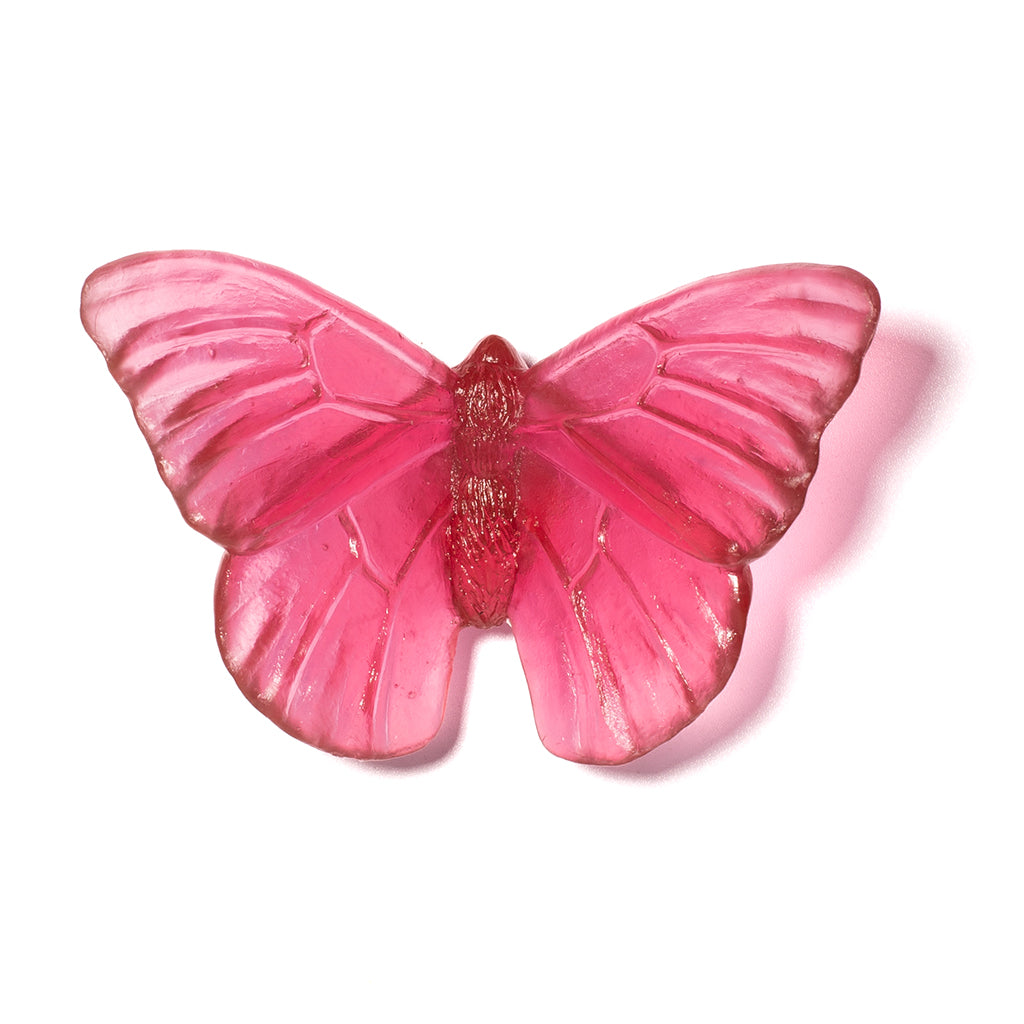 A translucent red glass butterfly sculpture, shown against a plain white background with a soft shadow.