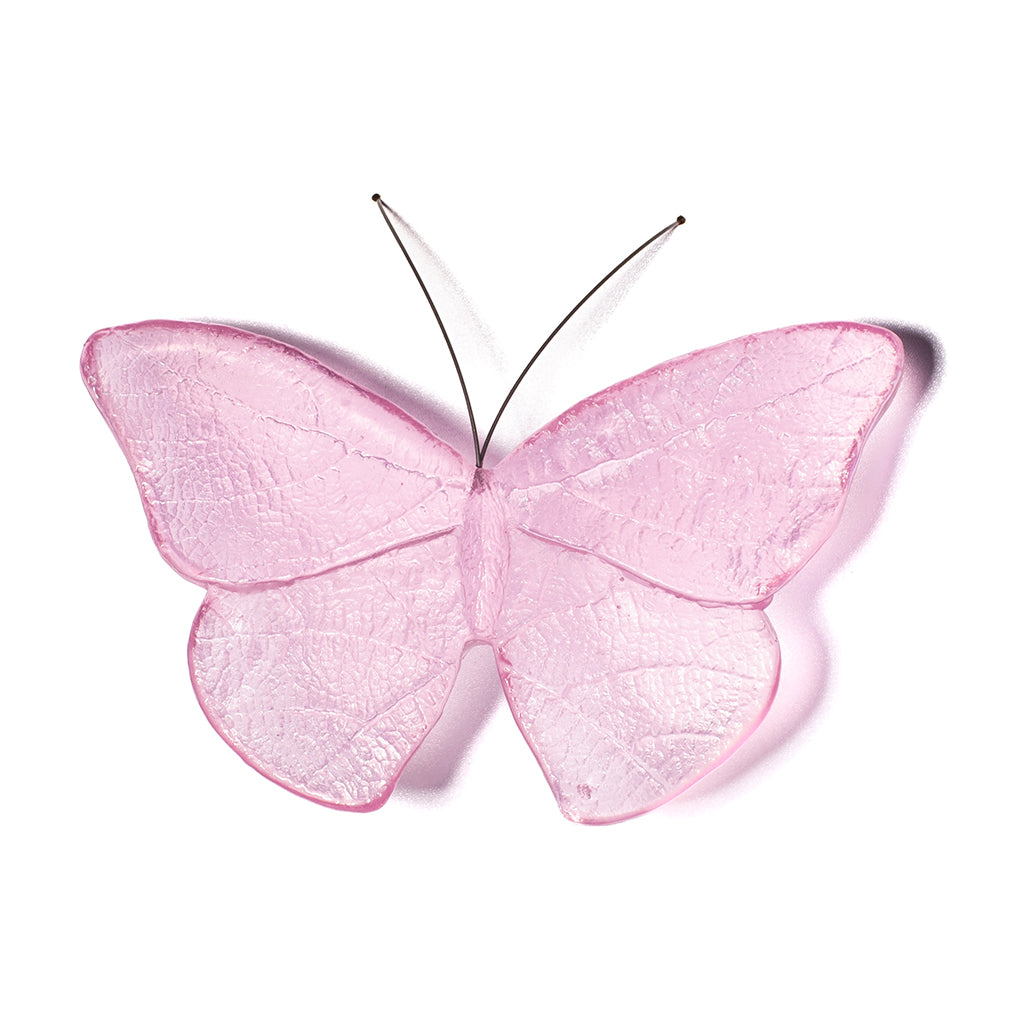 A pink butterfly-shaped wall hanging with a textured, translucent material and thin black wire supports, shown against a plain white background.
