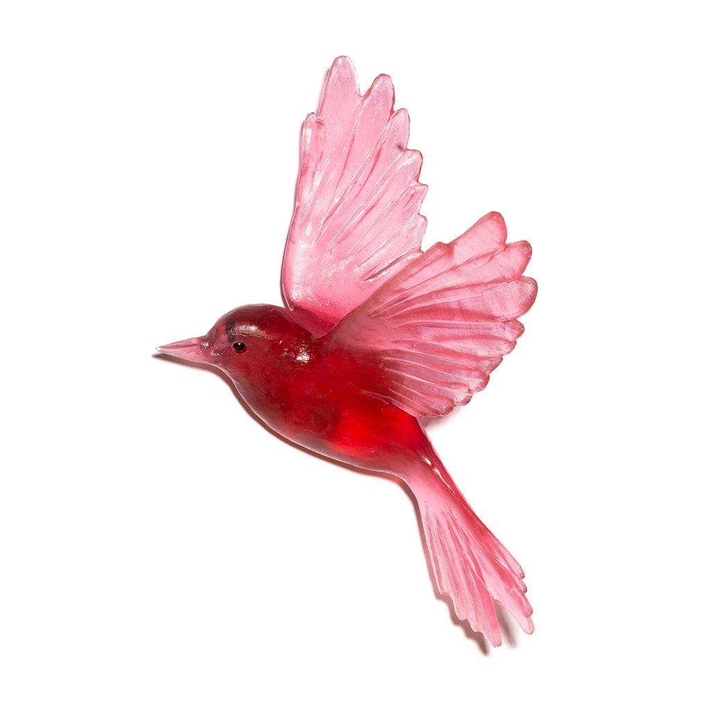 A translucent red bird-shaped decorative object with spread wings, shown on a plain white background.
