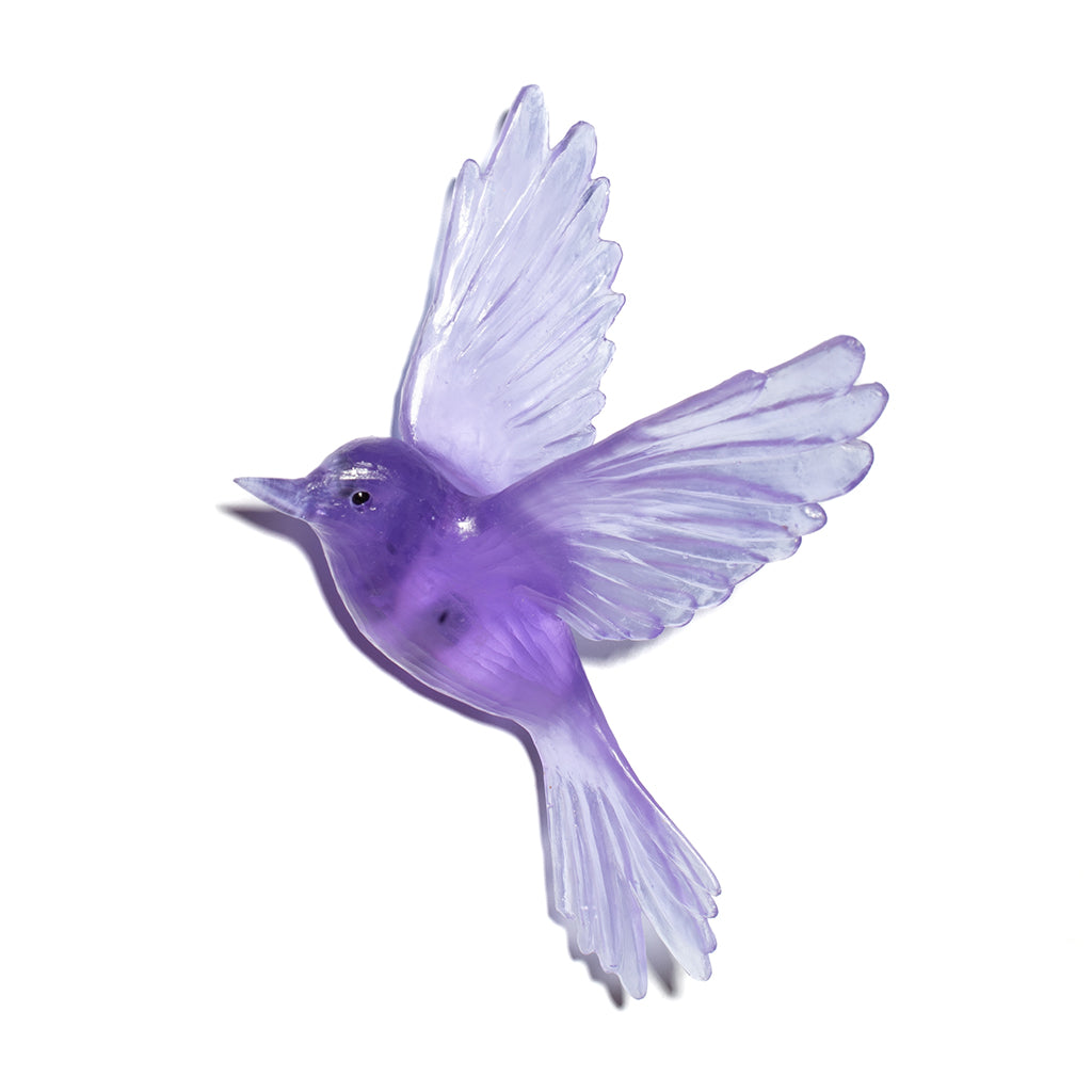 A translucent purple bird figurine with outstretched wings, shown against a plain white background.