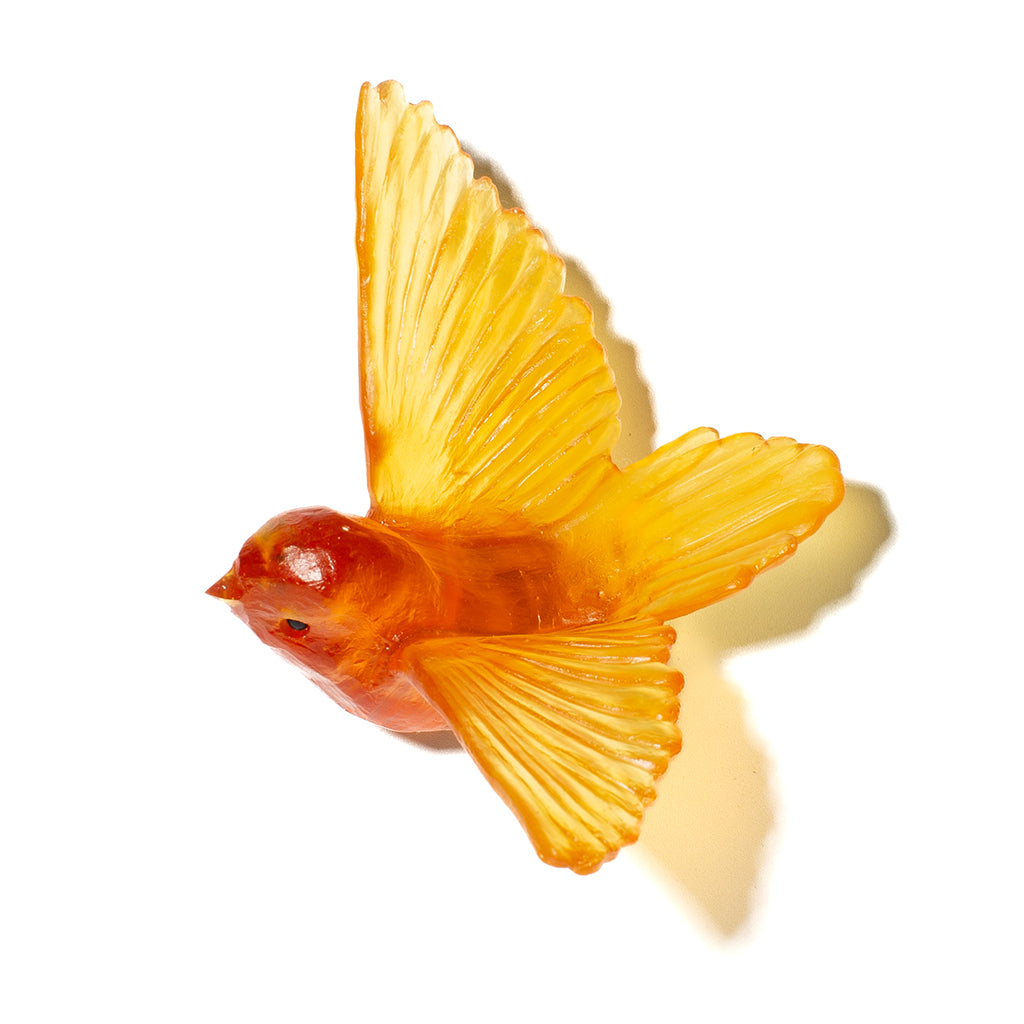 An orange translucent bird figurine with spread wings, shown on a plain white background with a soft shadow.