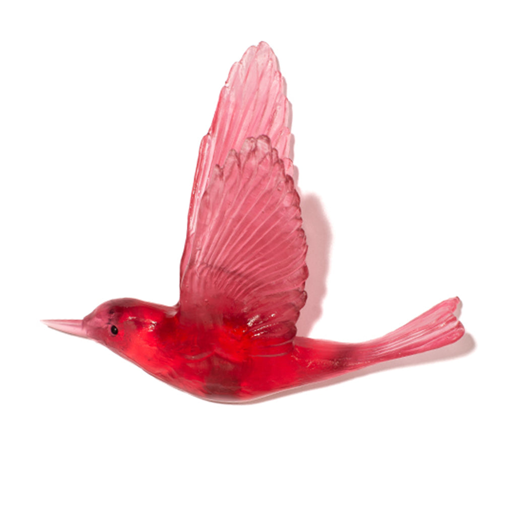 A translucent red bird figurine with spread wings, shown in profile against a plain white background.