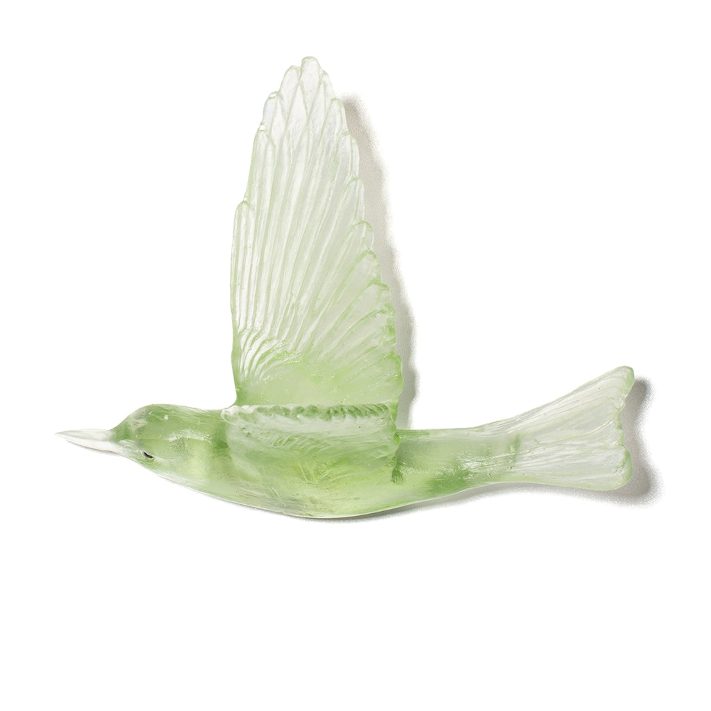 A light green translucent glass bird figurine with wings spread, shown against a plain white background.