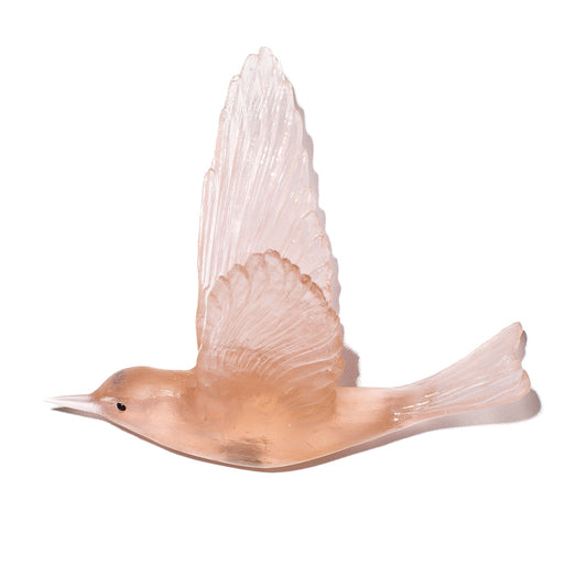 A translucent pale peach glass bird figurine with wings spread, shown on a plain white background.