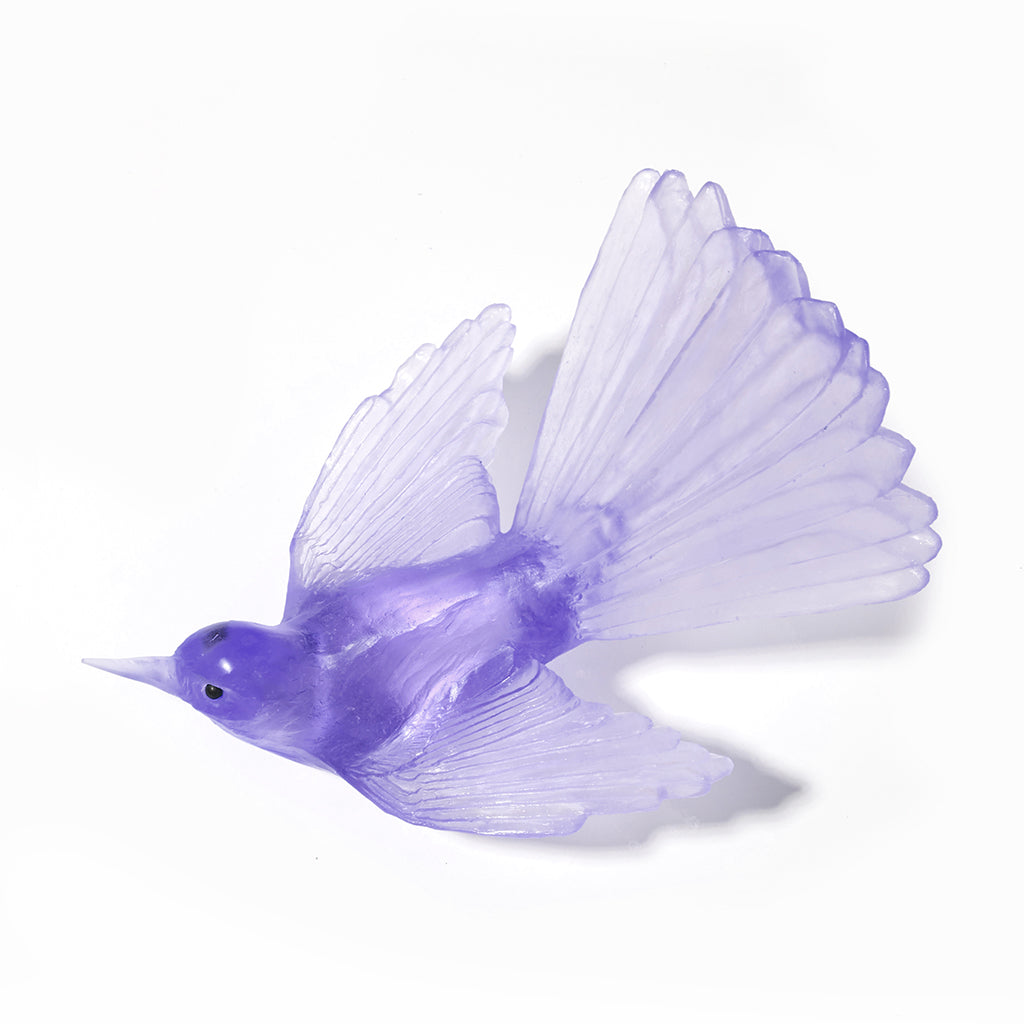 A translucent purple bird figurine with spread wings, shown on a clean white background.