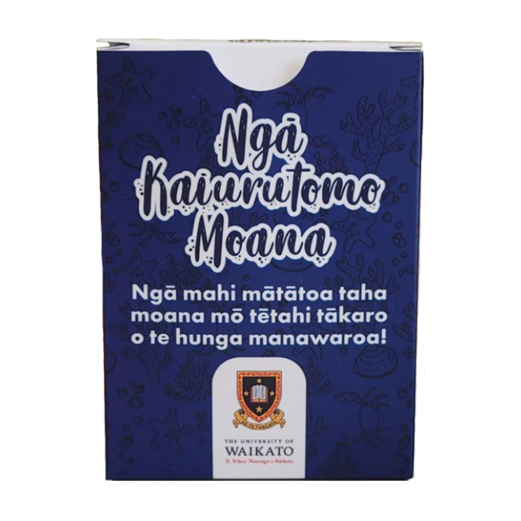 A rectangular blue product box with white text reading 'Ngá Kaiurutomo Moana' and additional white descriptive text below, plus a small Waikato University crest near the bottom. The box is photographed on a plain white background.