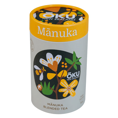 A cylindrical container of Mānuka blended tea with illustrations of manuka flowers and leaves on the label.