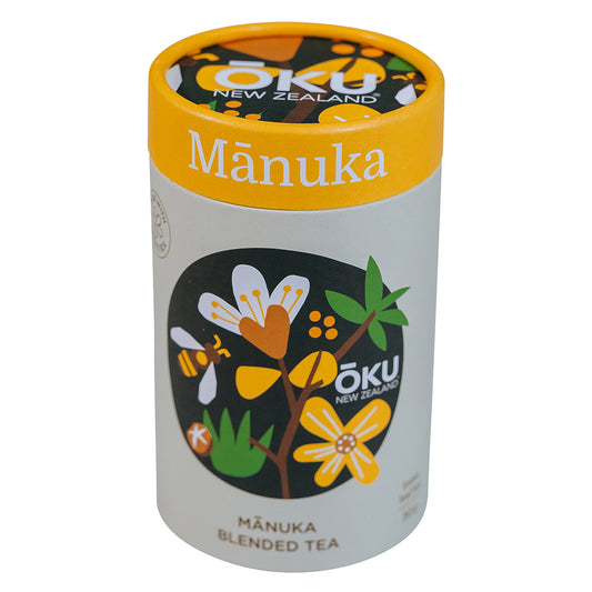A cylindrical container of Mānuka blended tea with illustrations of manuka flowers and leaves on the label.