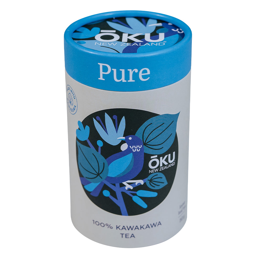 A cylindrical tin can of Oku Tea Pure, featuring a blue lid and a label with a blue and green color scheme, indicating 100% Kawakawa tea.