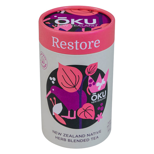 A cylindrical container of Oku Tea Restore with a pink lid, featuring illustrations of plants and the text 'NEW ZEALAND NATIVE HERB BLENDED TEA'.