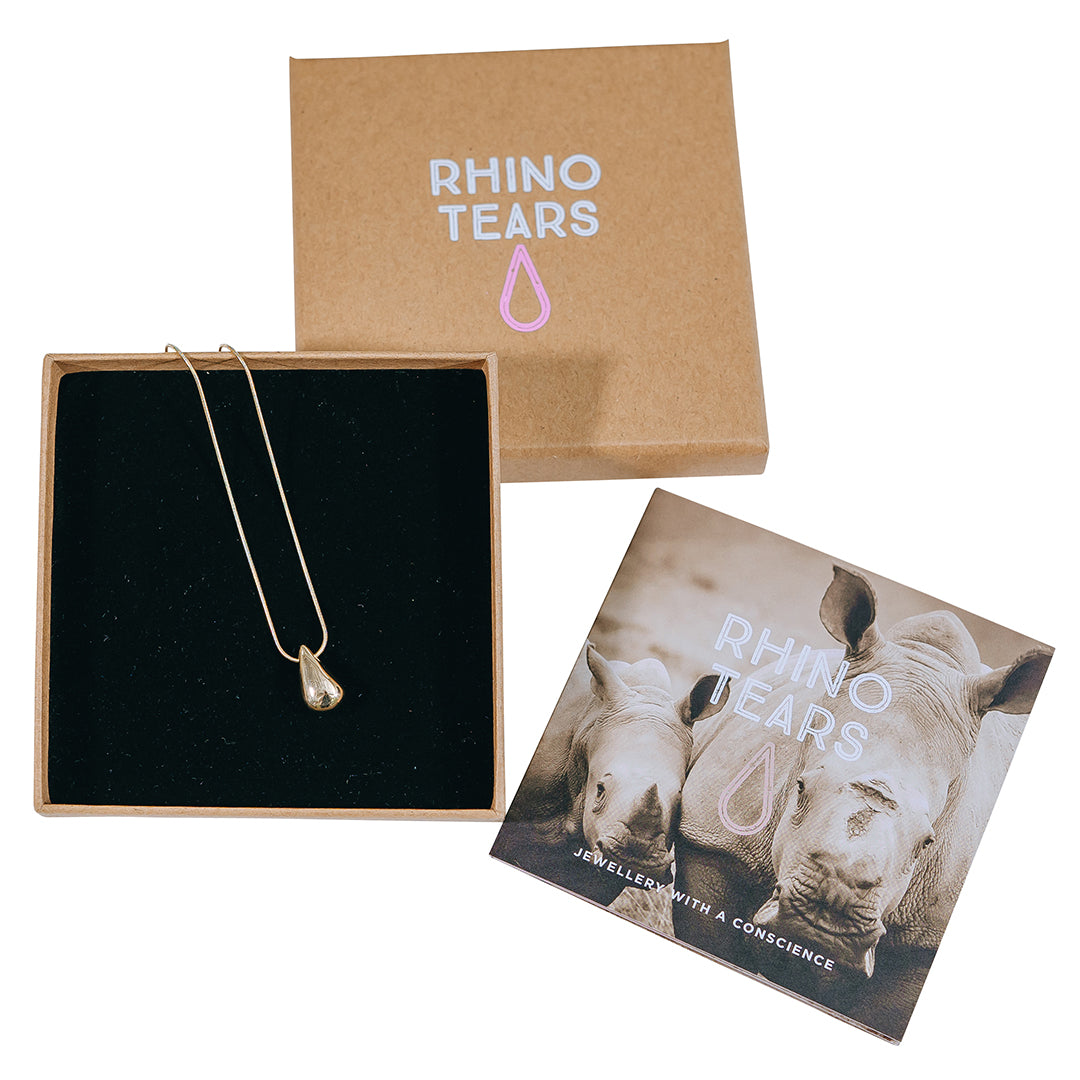 A gold-plated tear pendant necklace from the Rhino Tears collection, displayed in a presentation box with a branded card.