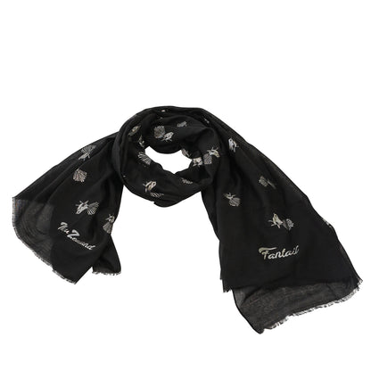A black scarf with silver foil print depicting New Zealand's native piwakawaka (fantail) bird.