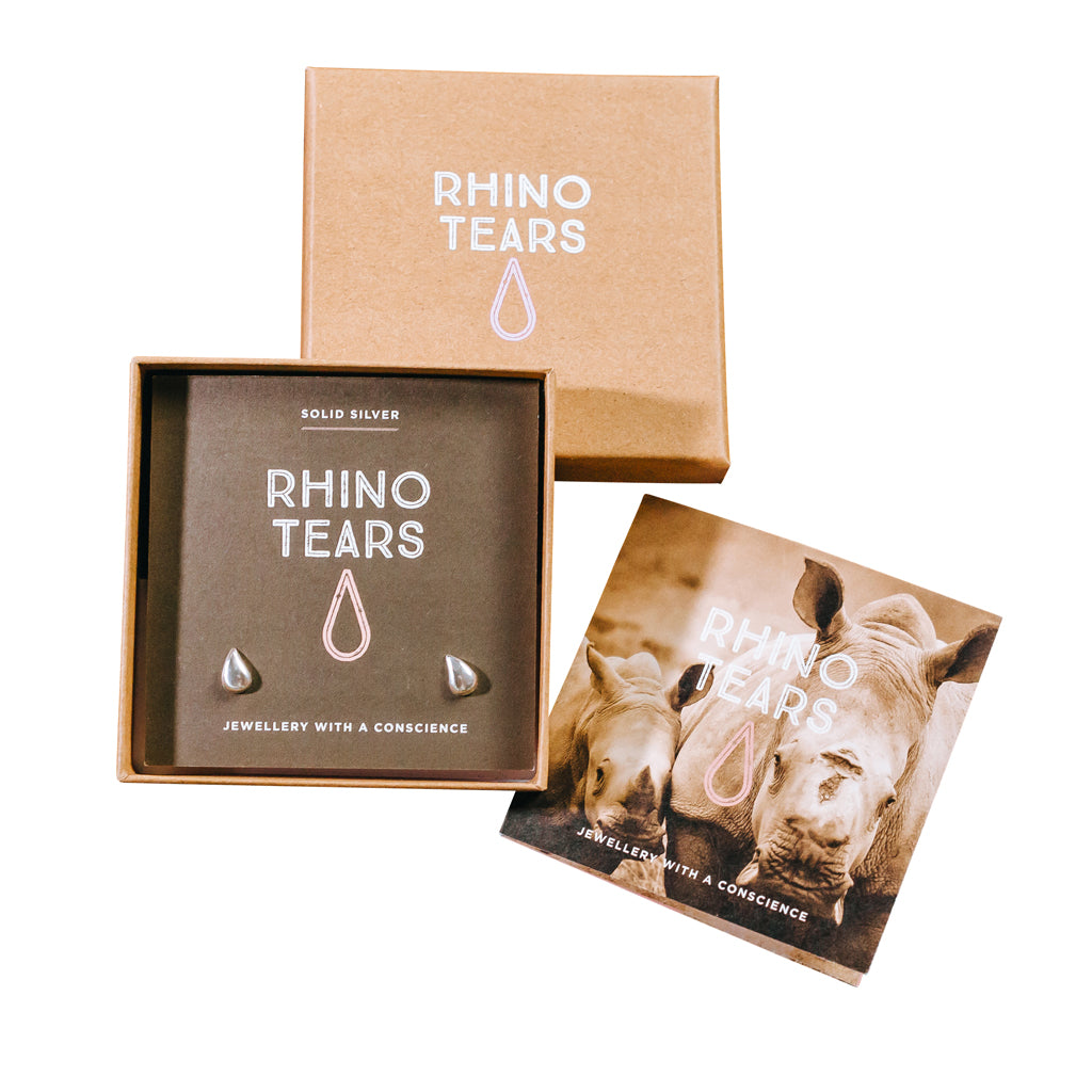  RHINO TEARS silver earrings displayed in an open cardboard box with the brand name visible, alongside a card with an image of a rhino.