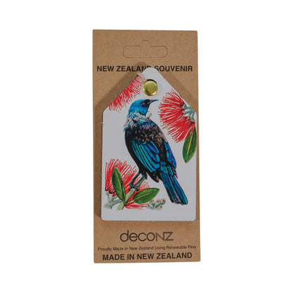 A Tūī and Pōhutukawa Decoration featuring a tui with black and blue feathers and red pohutukawa flowers.