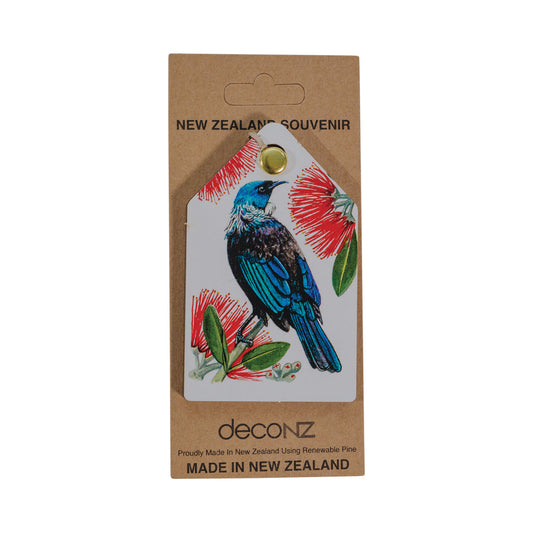 A Tūī and Pōhutukawa Decoration featuring a tui with black and blue feathers and red pohutukawa flowers.