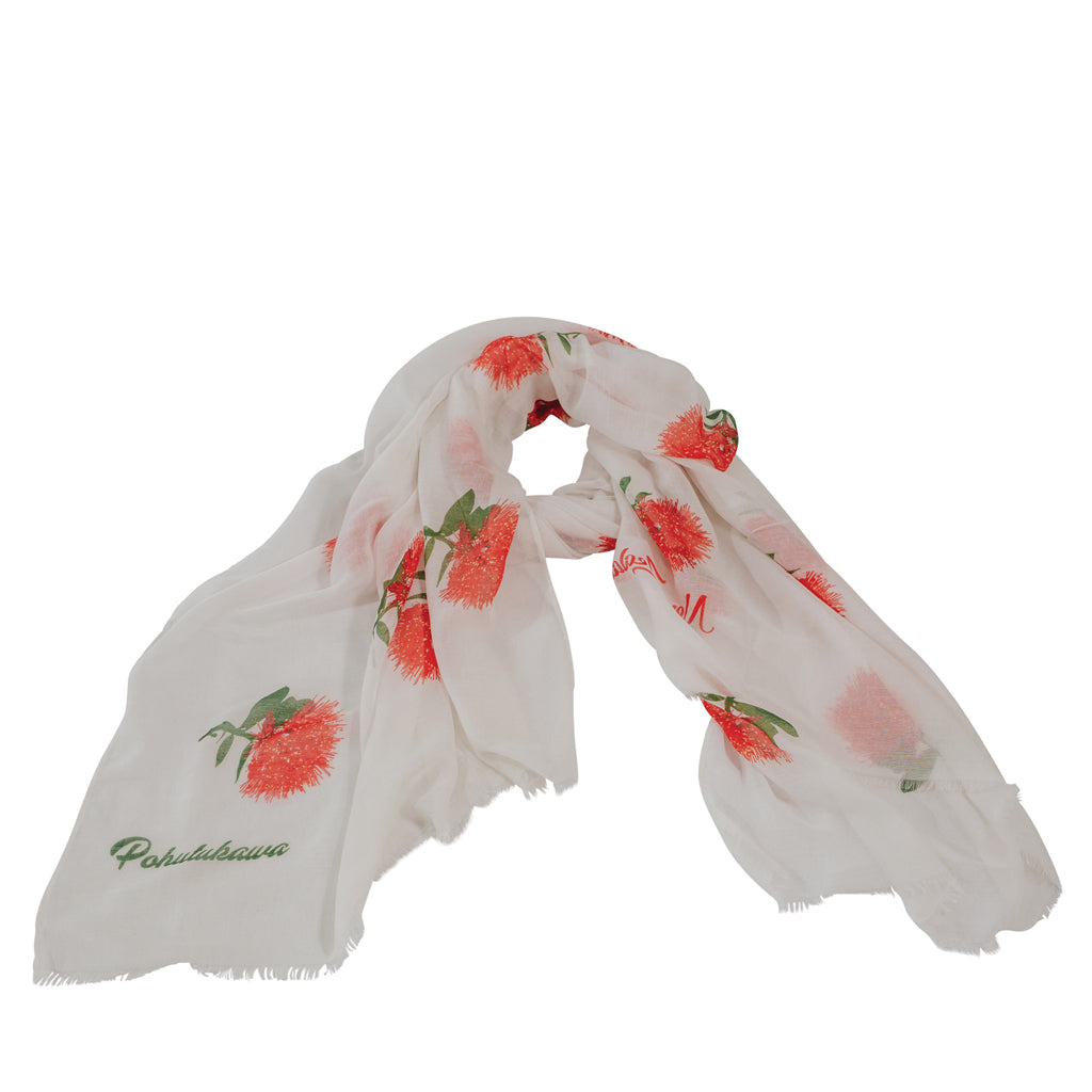 A white scarf with red pohutukawa flower patterns and green leaves, displayed on a plain background.